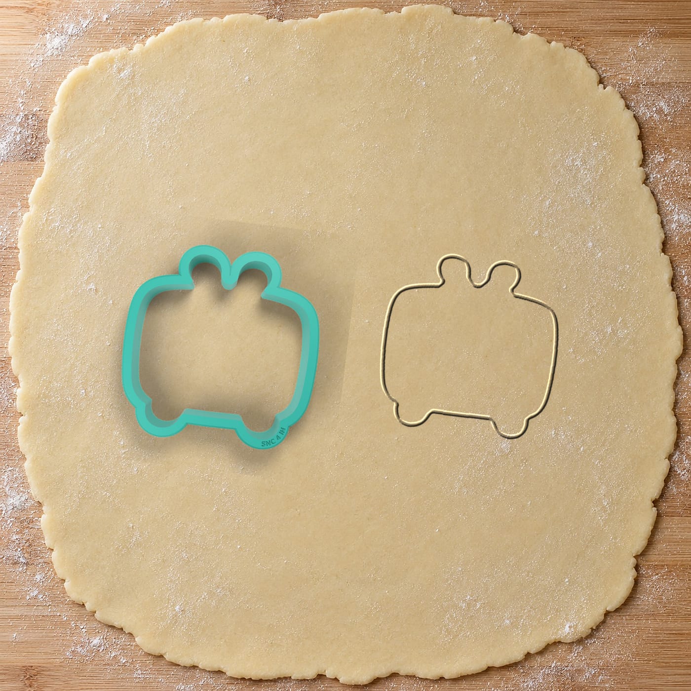 A teal Splash N Color cutter on rolled dough, with the shape it just cut
